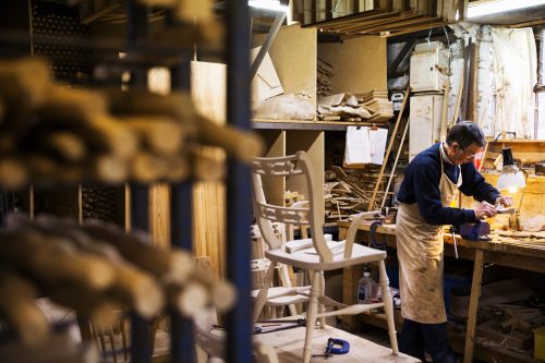 Man working on a piece of wood in a carpentry workshop.